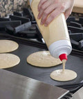 Pouring pancake batter on griddle